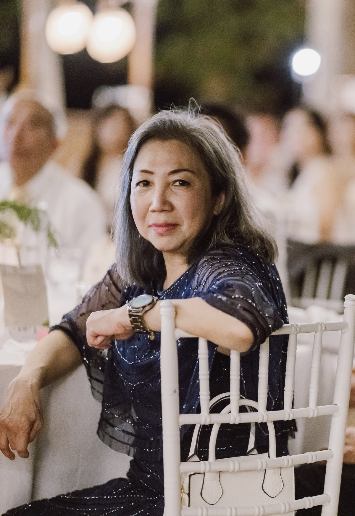 Anita Po Chu Pong, the artist, seated at a candlelit evening table